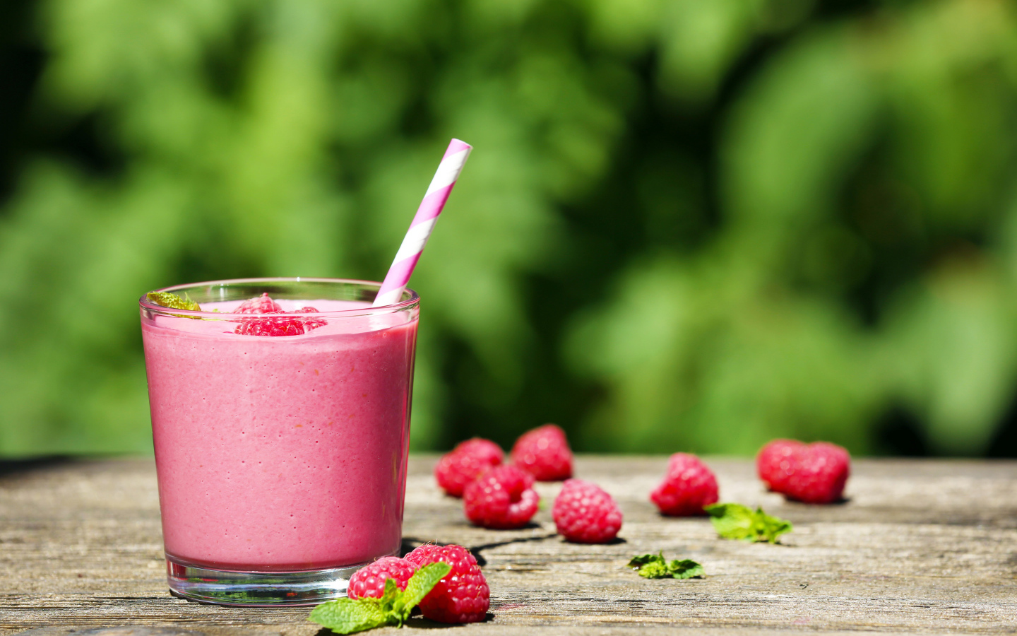 Коктейль в стакане с трубочкой и ягодами малины