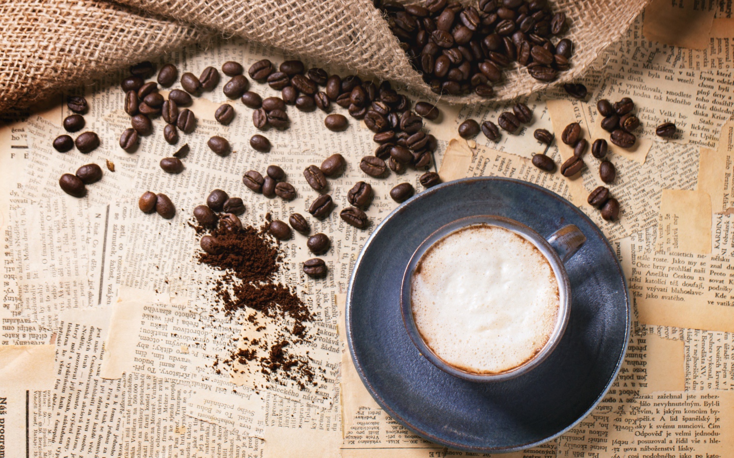 Чашка кофе на столе со старыми газетами и зернами