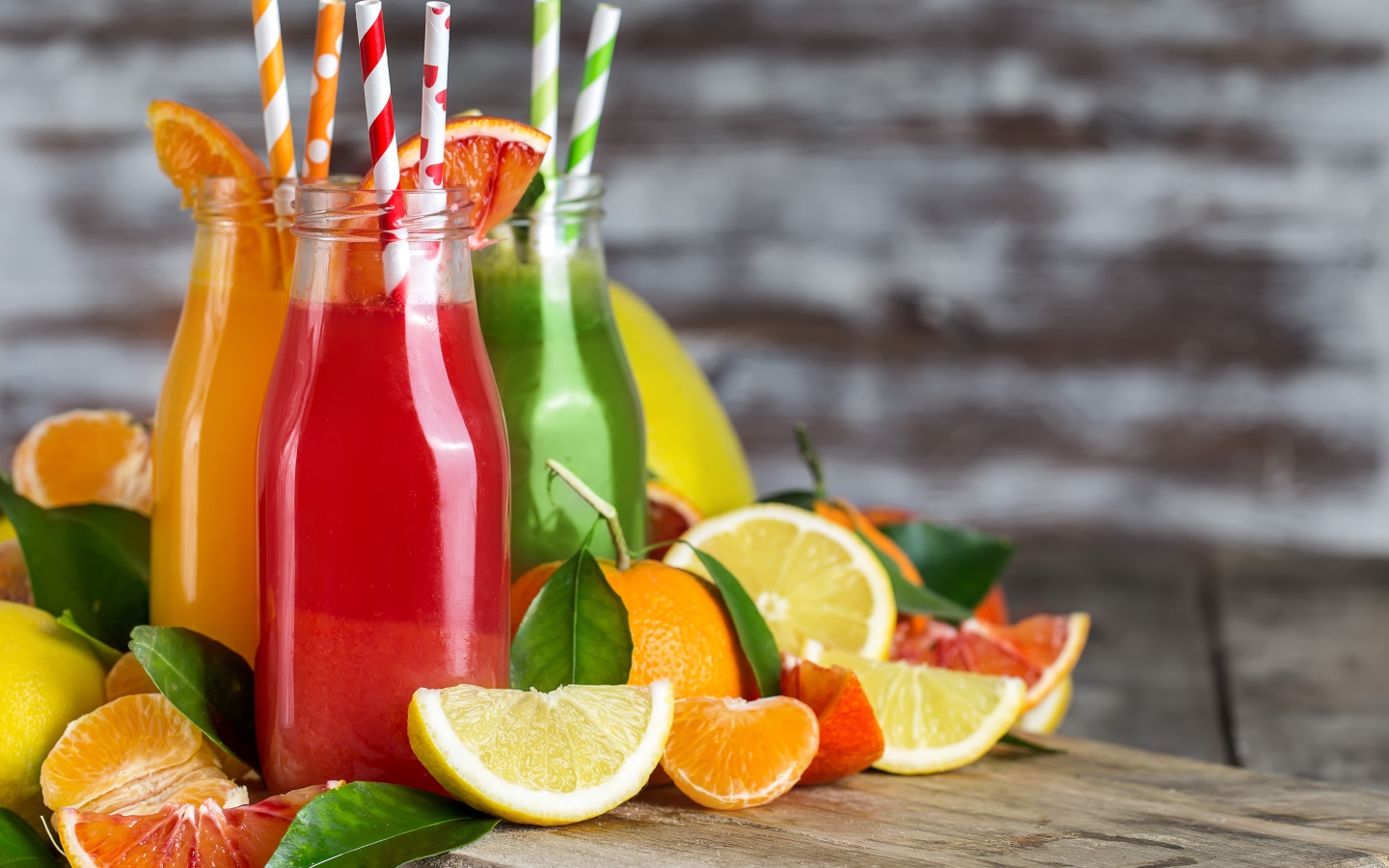 Фруктовое смузи на столе в бутылках с трубочками