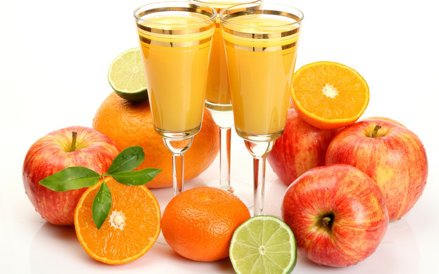 Сок в фужерах на столе с яблоками и мандаринами 