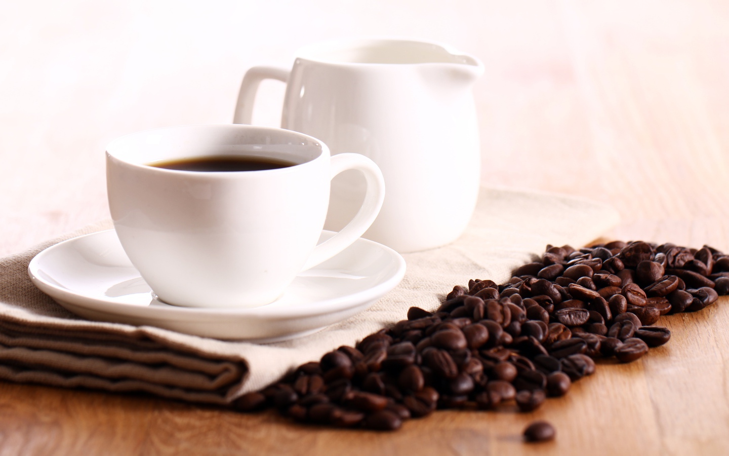 Белая чашка кофе на столе с молоком и зернами