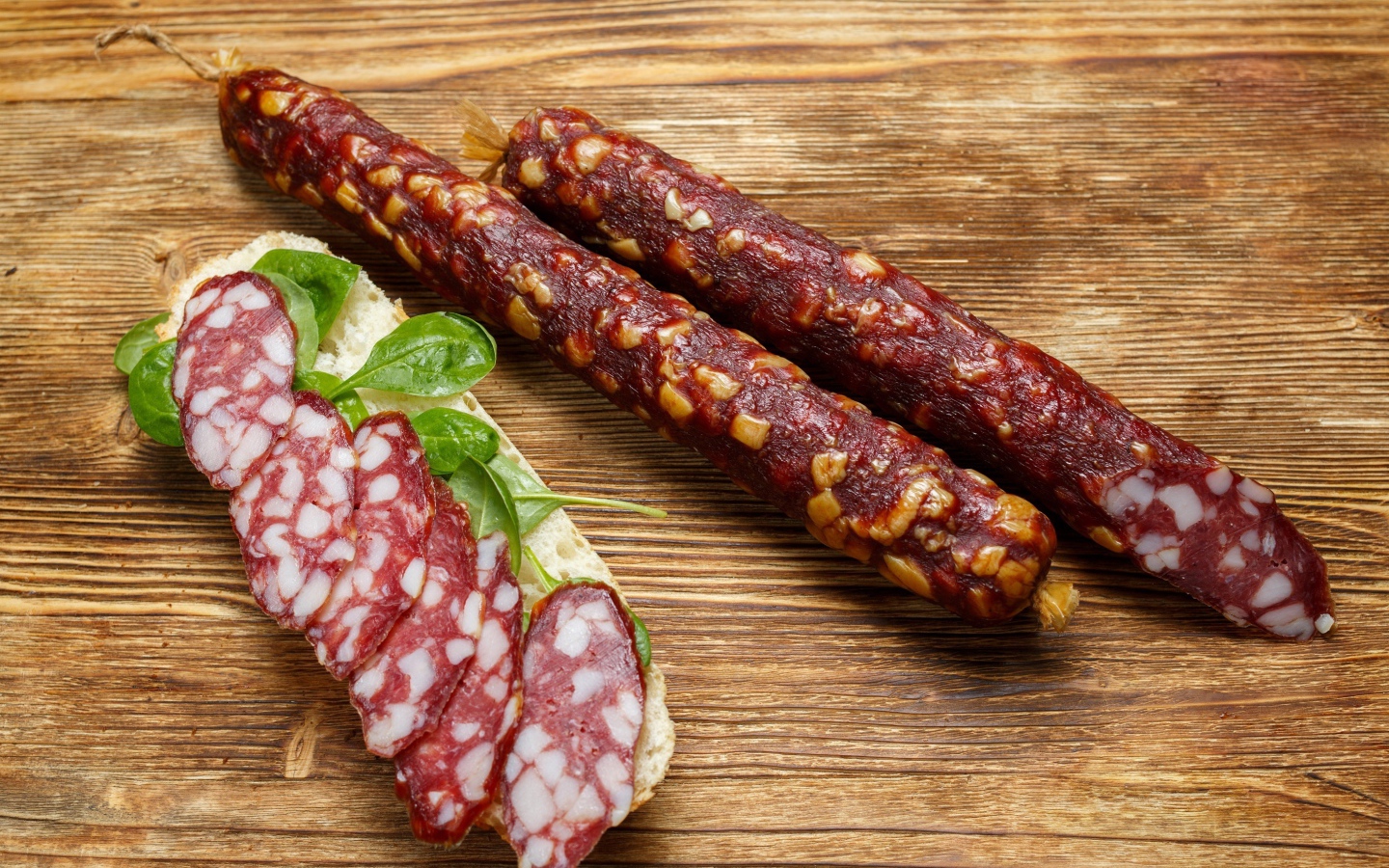 Вкусная сухая колбаса на столе с бутербродом