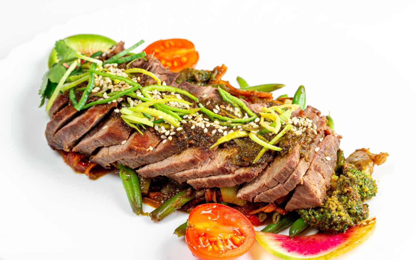 Мясо нарезанное кусочками на белом фоне с овощами