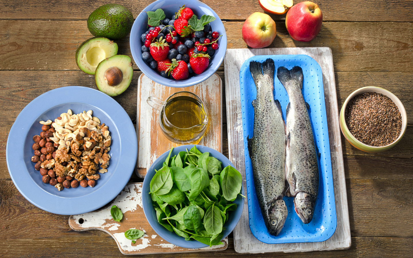 Fresh fish on a table with nuts, basil and berries