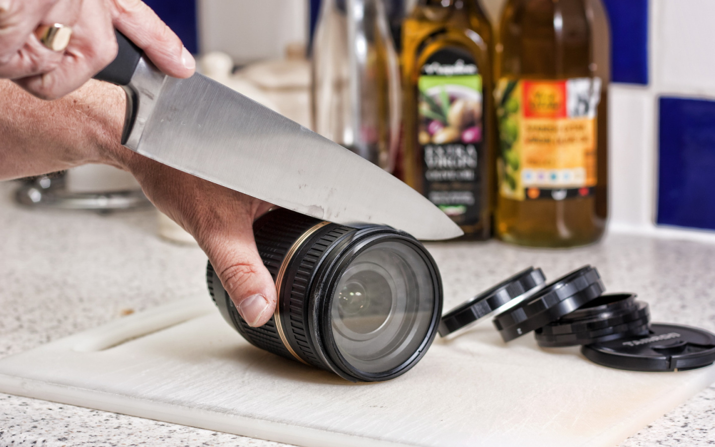 Мужчина нарезает ножом объектив фотоаппарата 