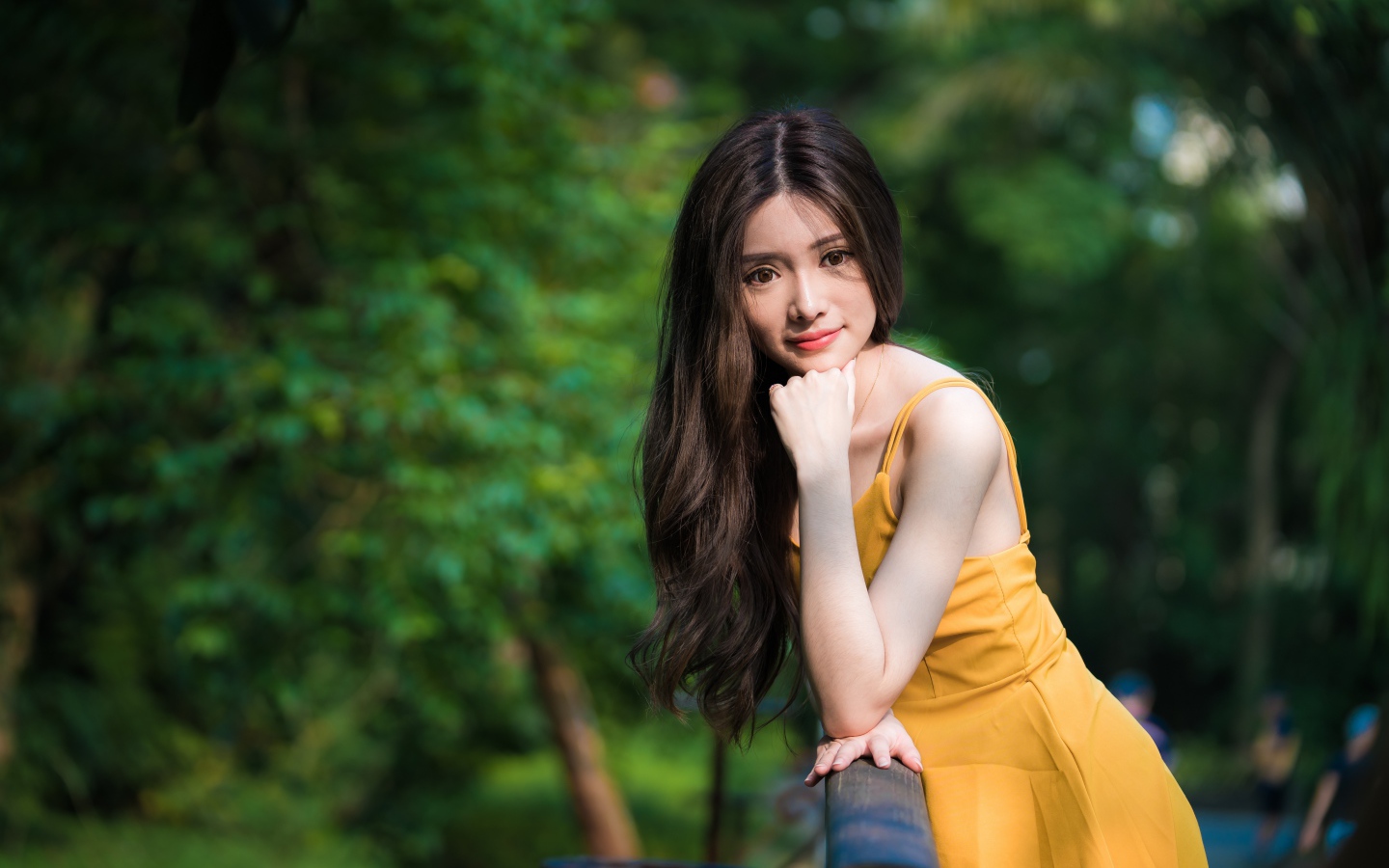 Девушка азиатка с большими карими глазами в желтом платье 