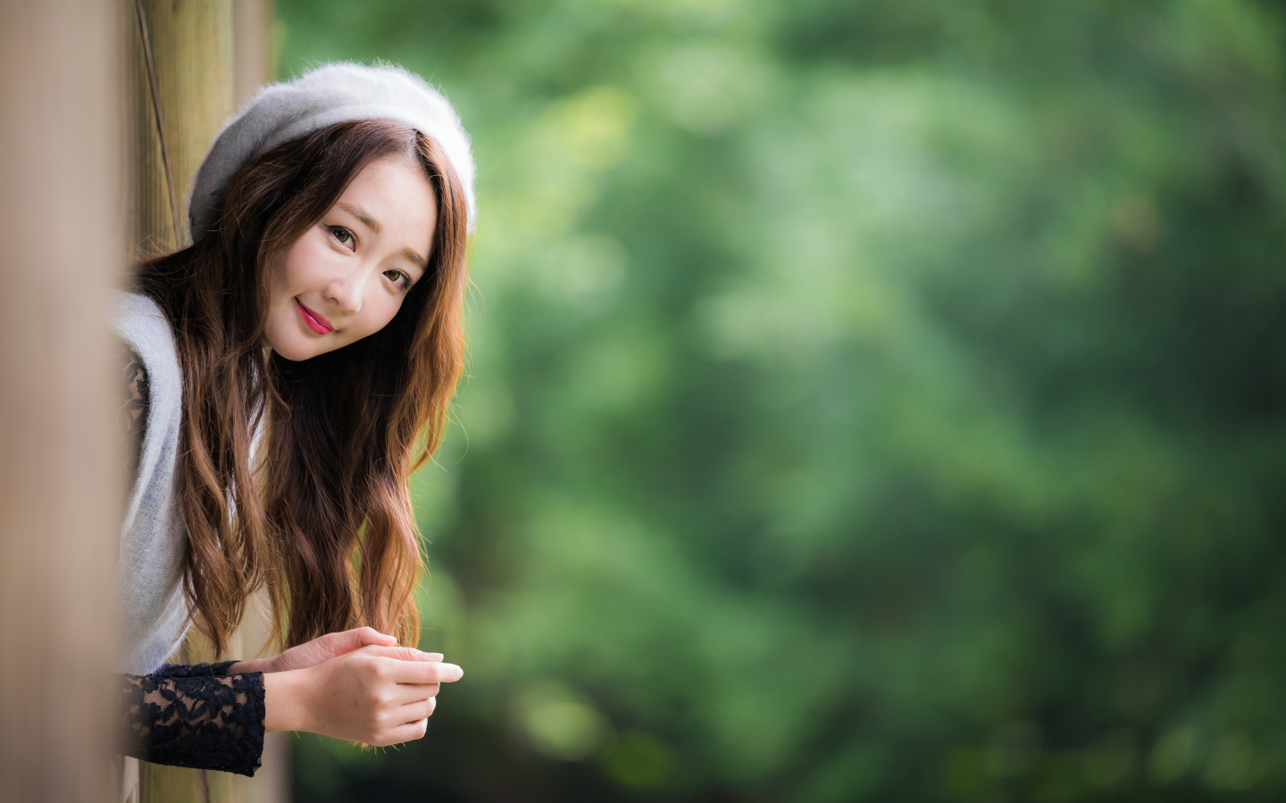 Азиатка в берете выглядывает из окна