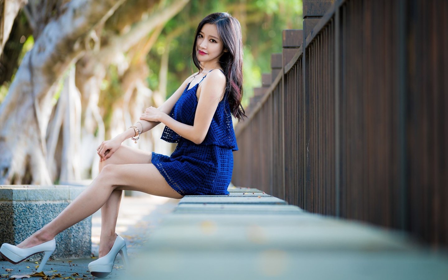 Красивая девушка азиатка в синем платье в парке