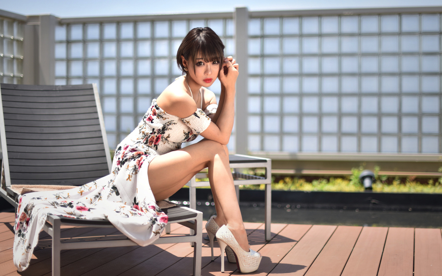 Красивая девушка азиатка сидит на шезлонге 