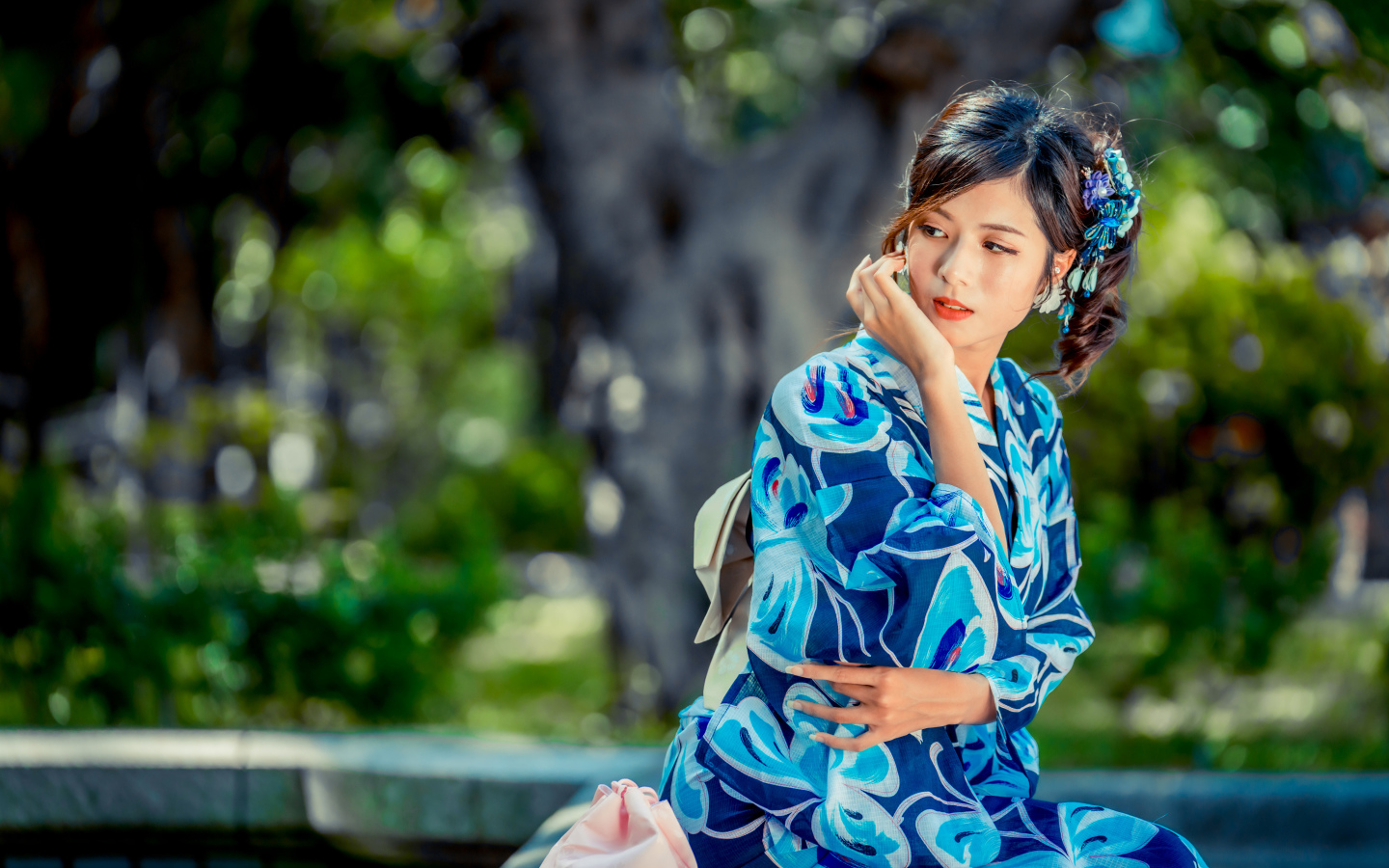 Красивая азиатка в разноцветном кимоно в парке