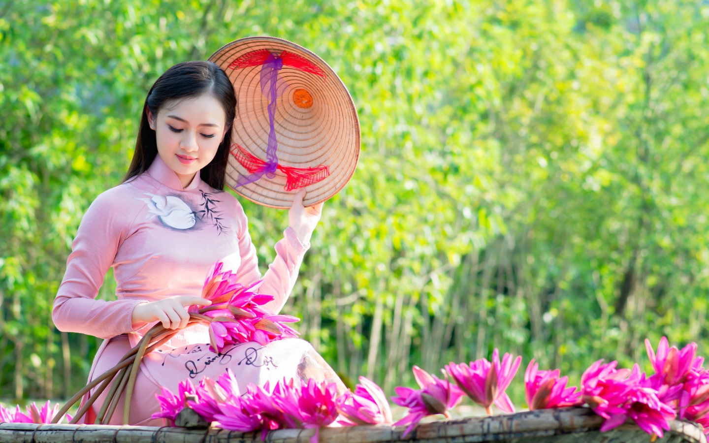 Beautiful asian girl in a boat with lotus flowers