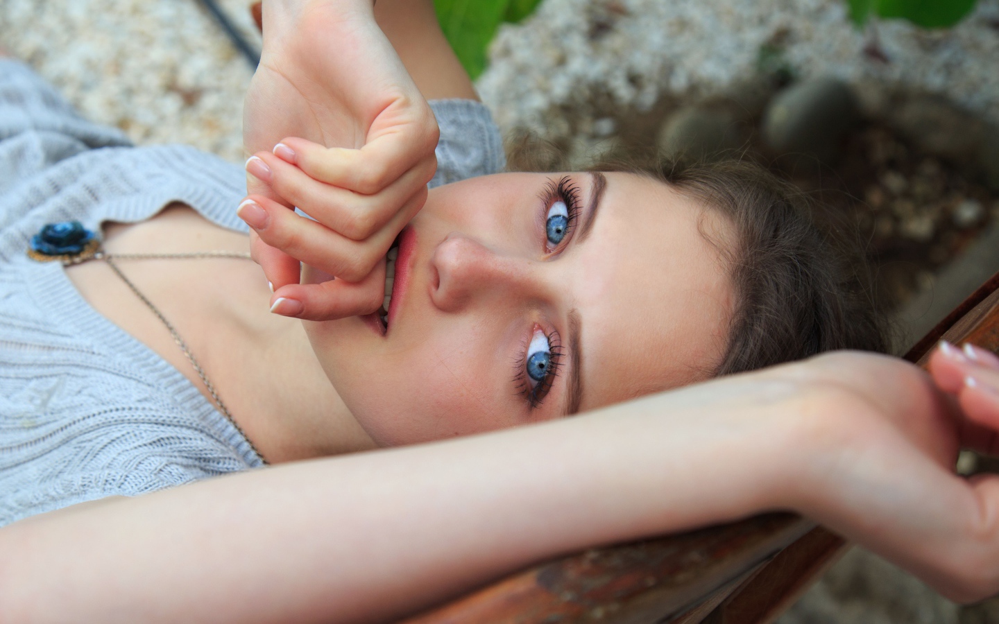 Красивая голубоглазая девушка с рукой у рта