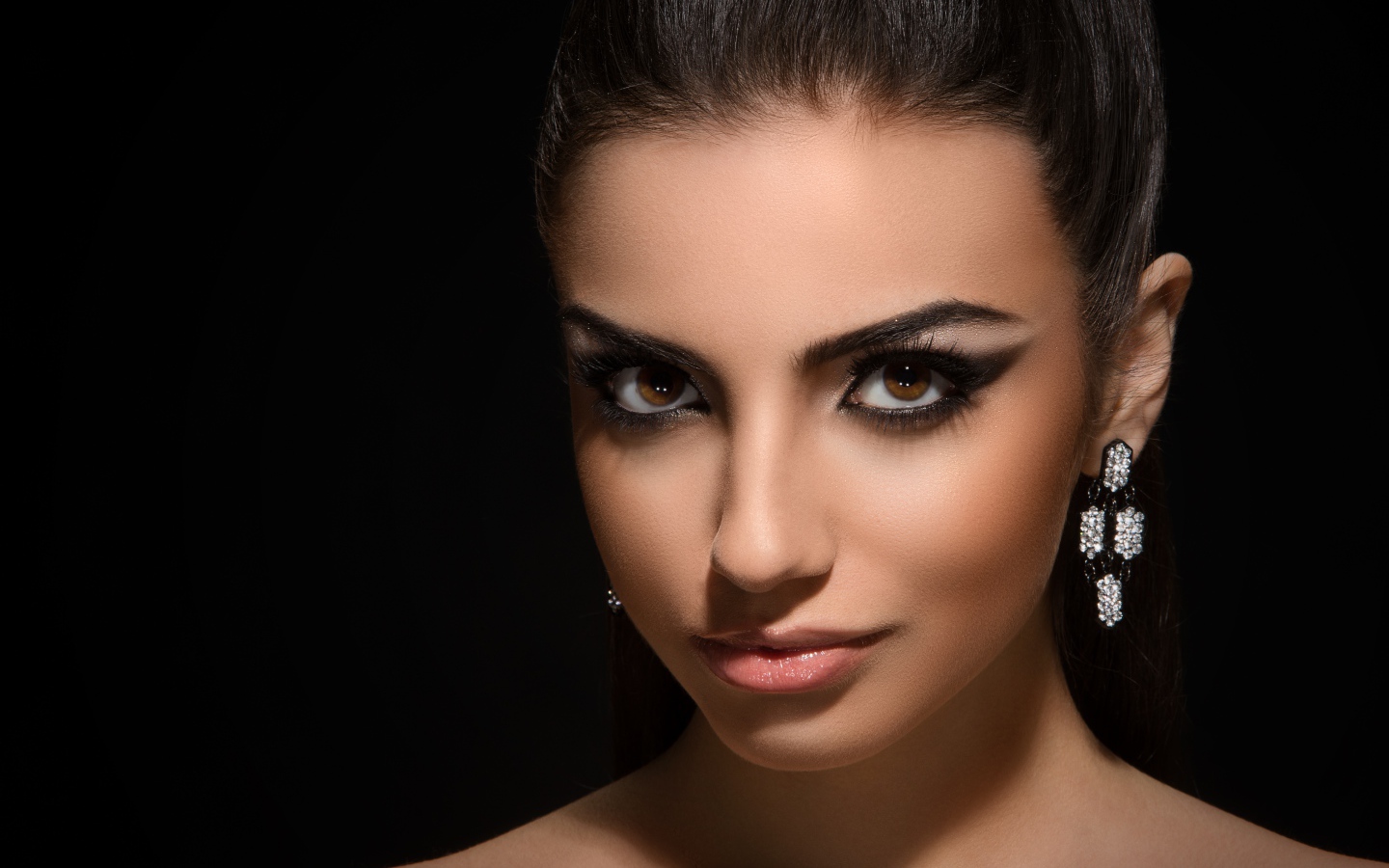 Красивая кареглазая девушка с прической на черном фоне