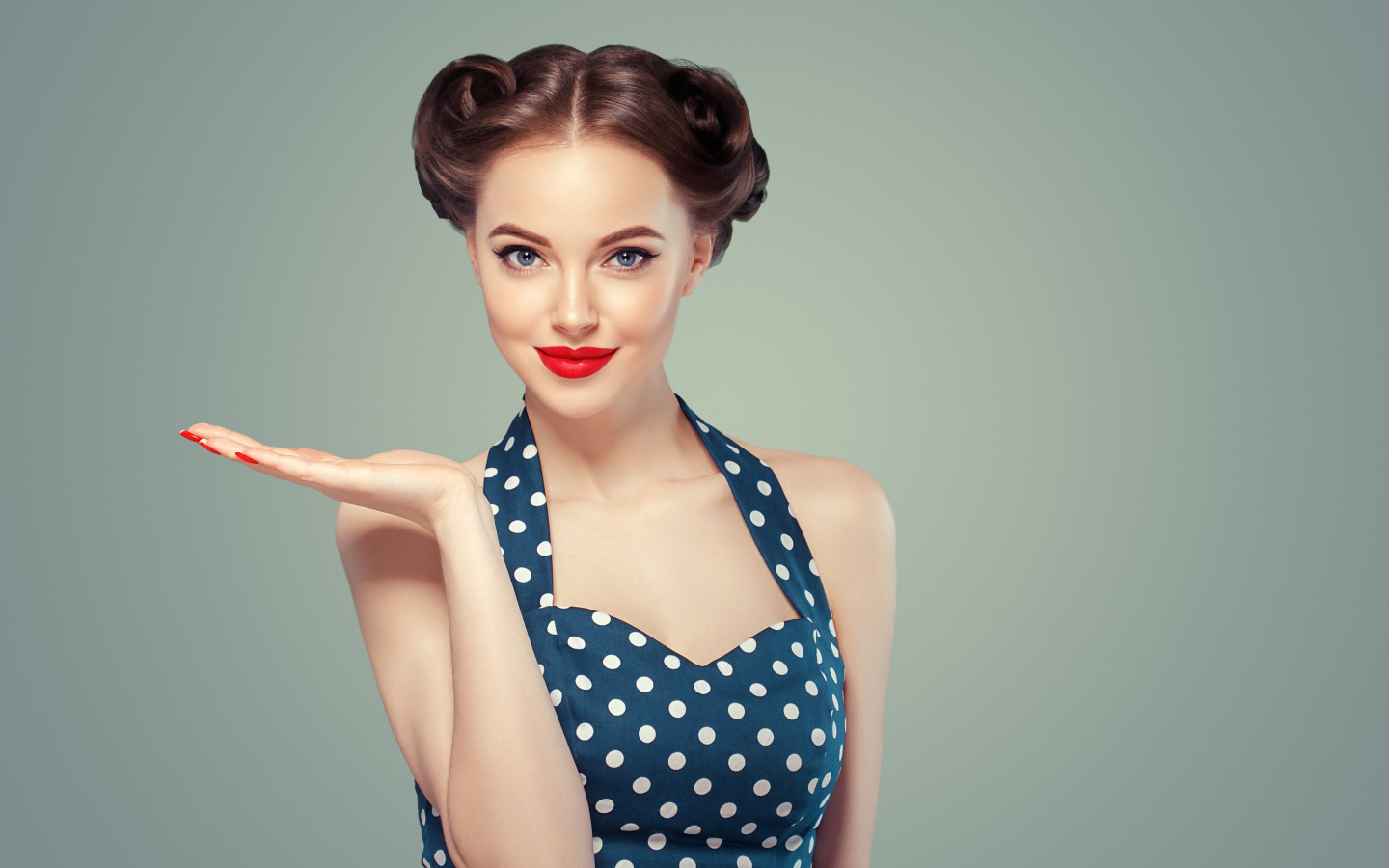 Красивая девушка в платье в горошек на сером фоне