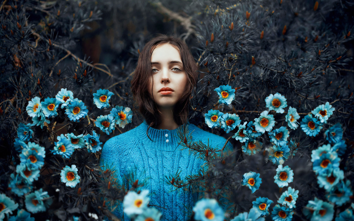 Красивая девушка колючих зарослях с голубыми цветами