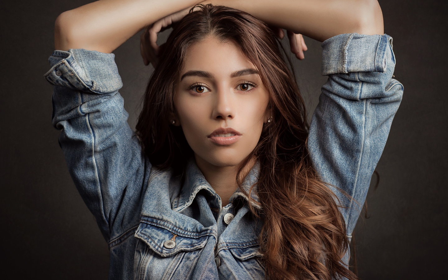 Красивая длинноволосая шатенка в джинсовой куртке 