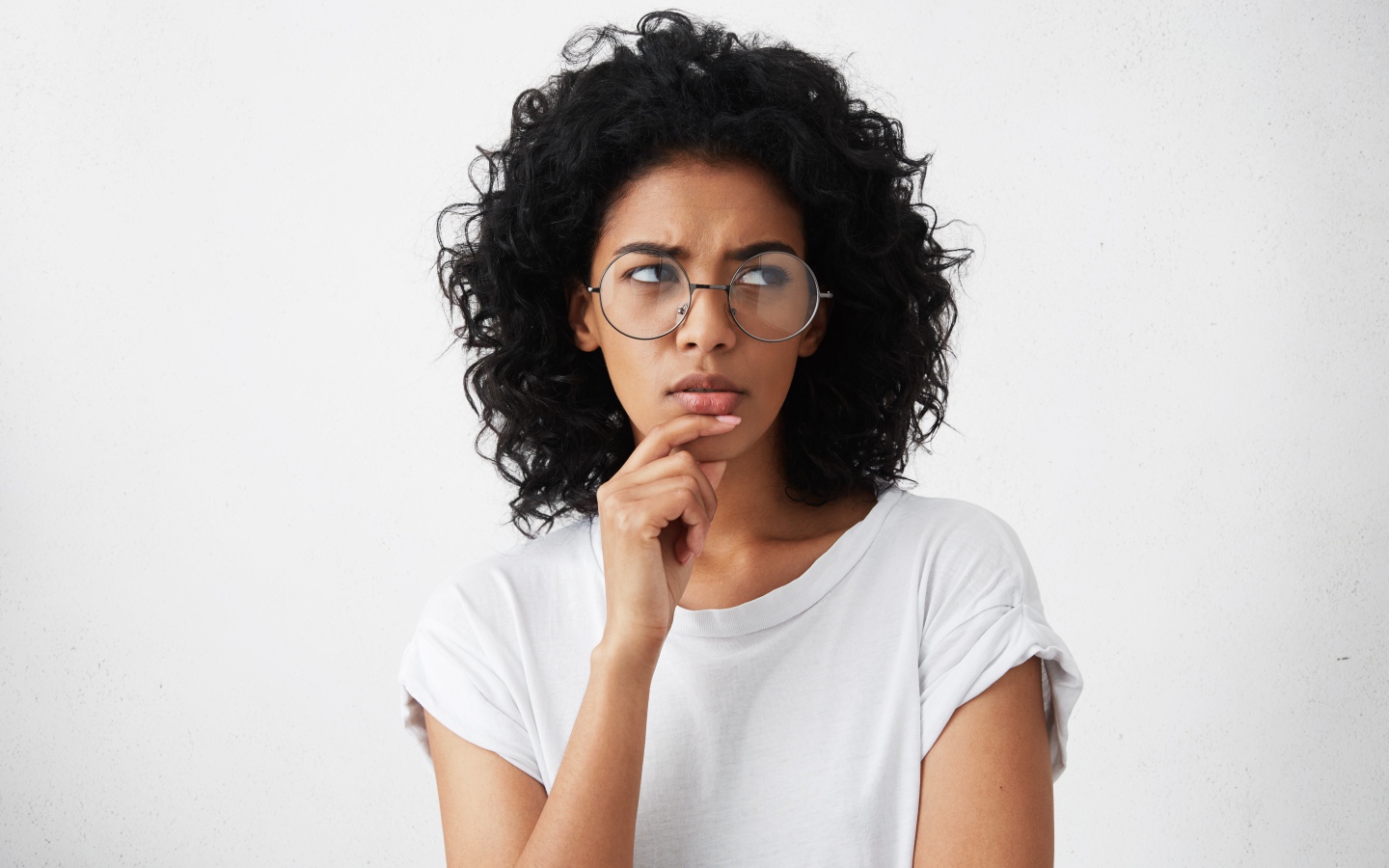 Темноволосая девушка в очках на сером фоне