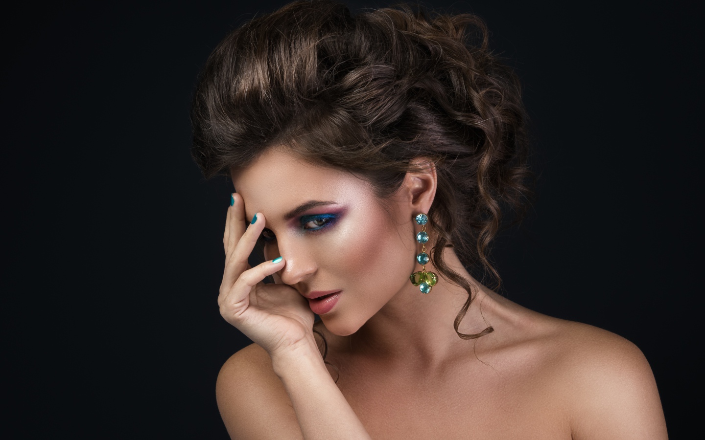 Девушка с красивой вечерней прической на сером фоне