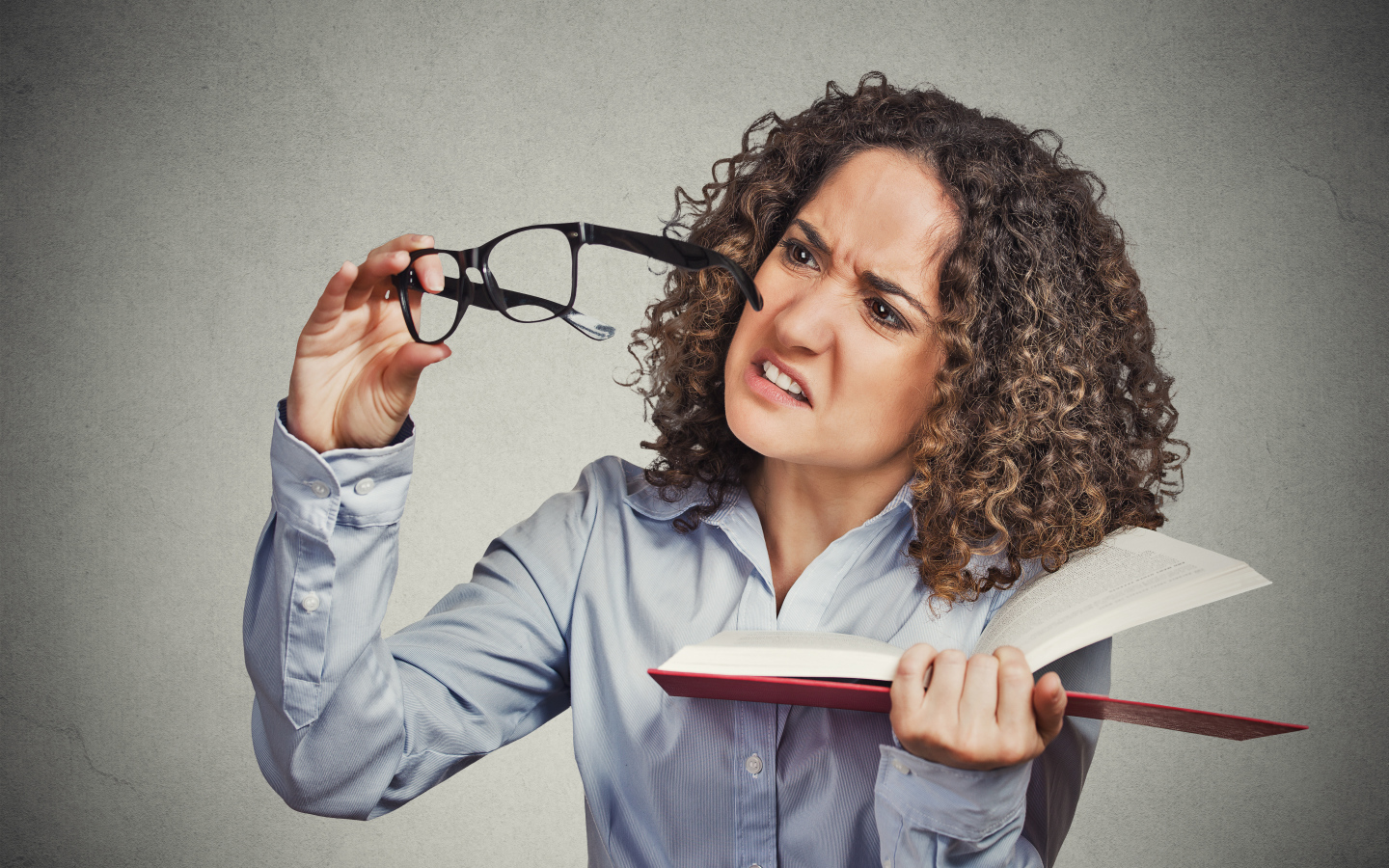 Девушка с книгой с очками в руке