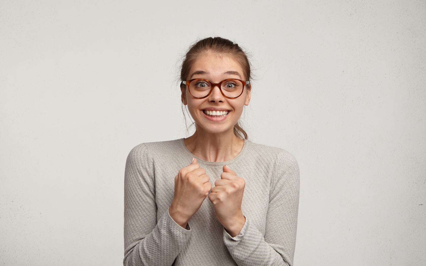 Радостная девушка в очках для зрения на сером фоне 