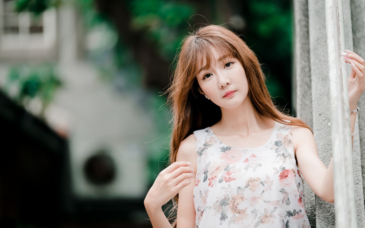 Длинноволосая азиатка стоит у стены 