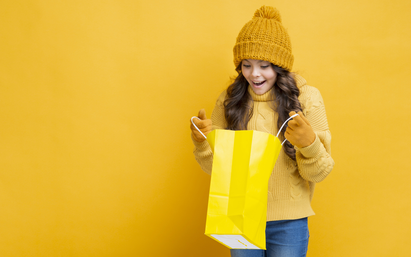Улыбающаяся девушка в теплом свитере  с пакетом в руках 
