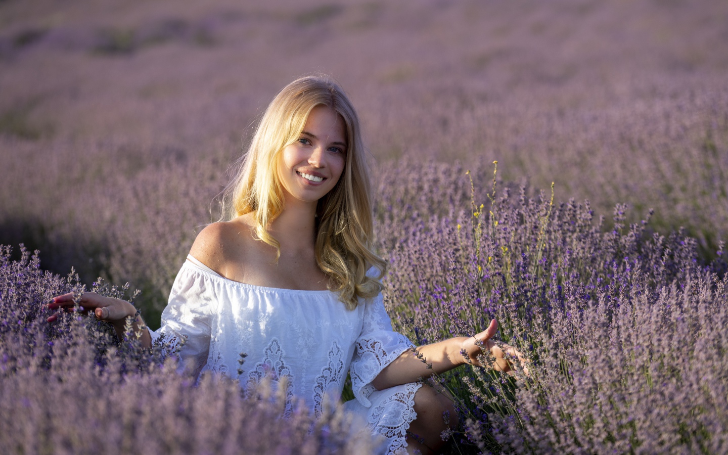 Улыбающаяся девушка в белом платье на лавандовом поле 
