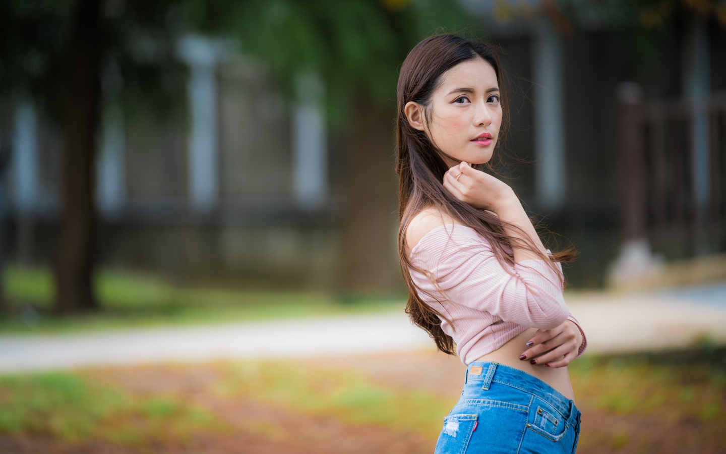 Молодая азиатка с длинными волосами в синих джинсах