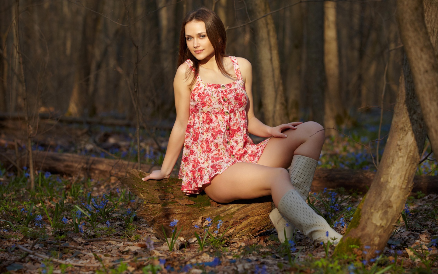 Молодая девушка в коротком платье в лесу весной