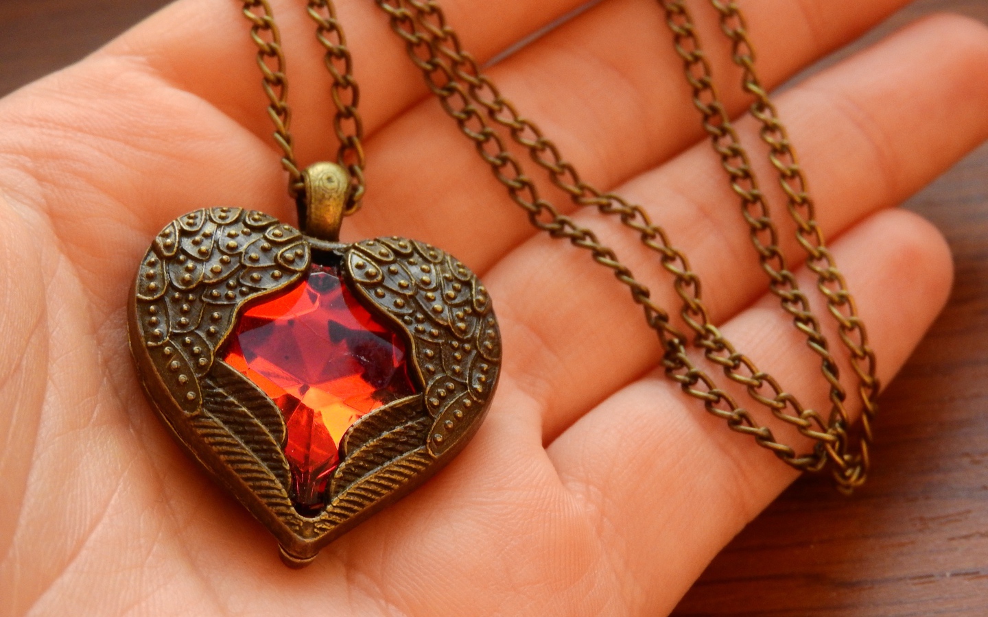 Кулон в форме сердца на ладони 