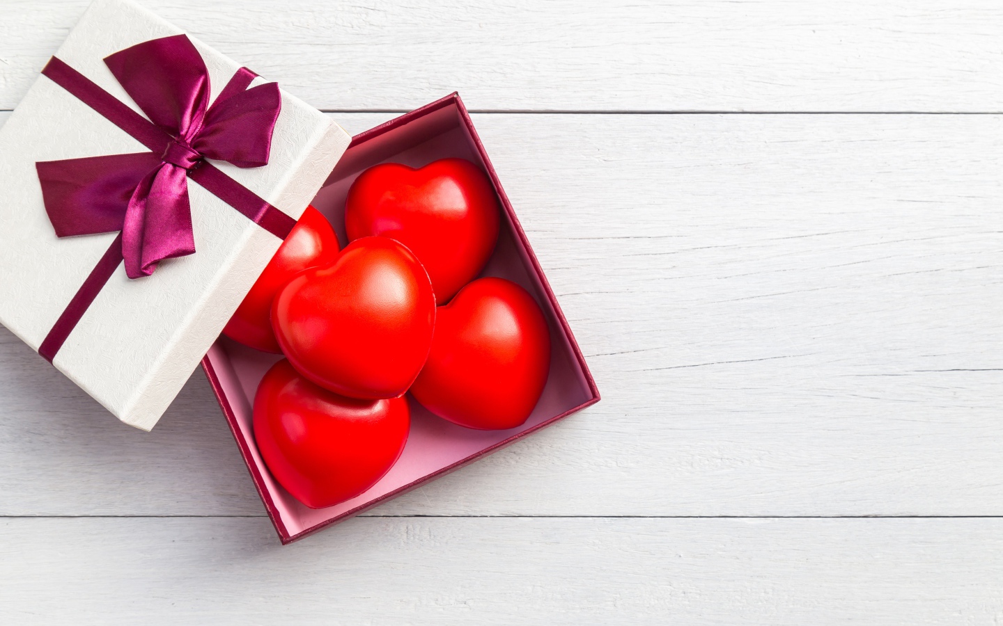 Красные сердечки в коробке на сером фоне