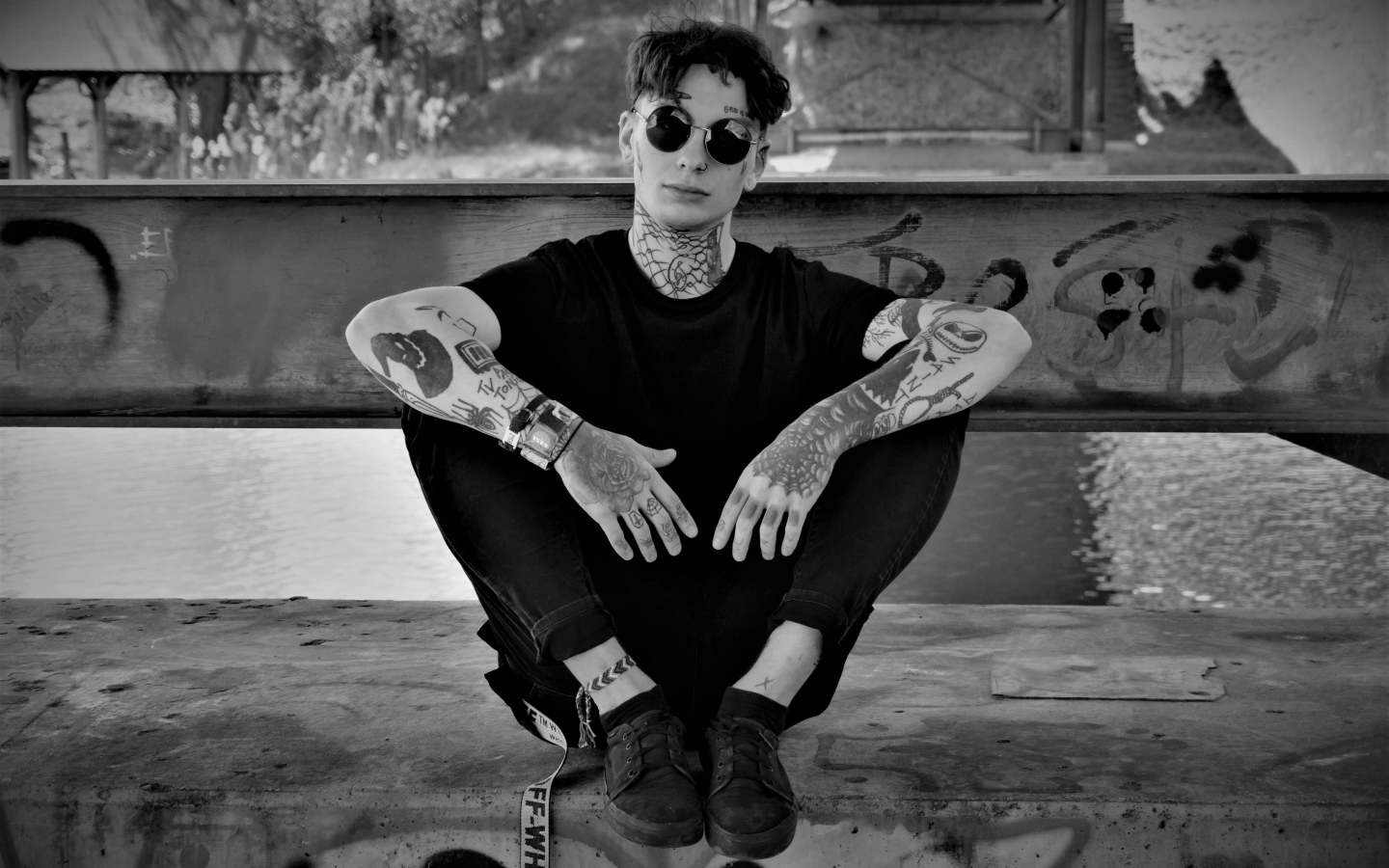 A man in black glasses with tattoos on his body.