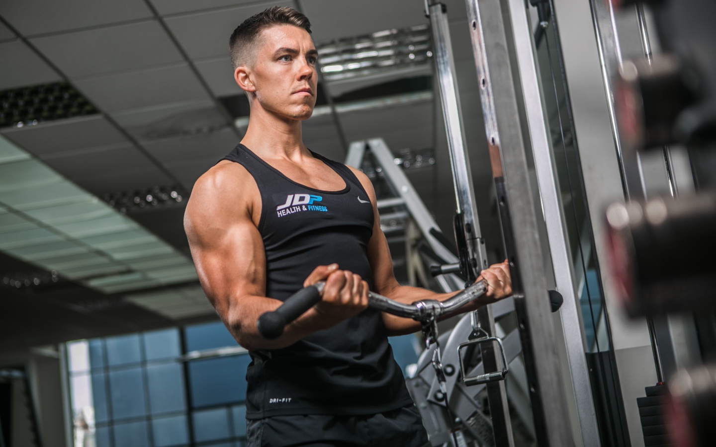 Накаченный мужчина занимается на тренажере в спортзале