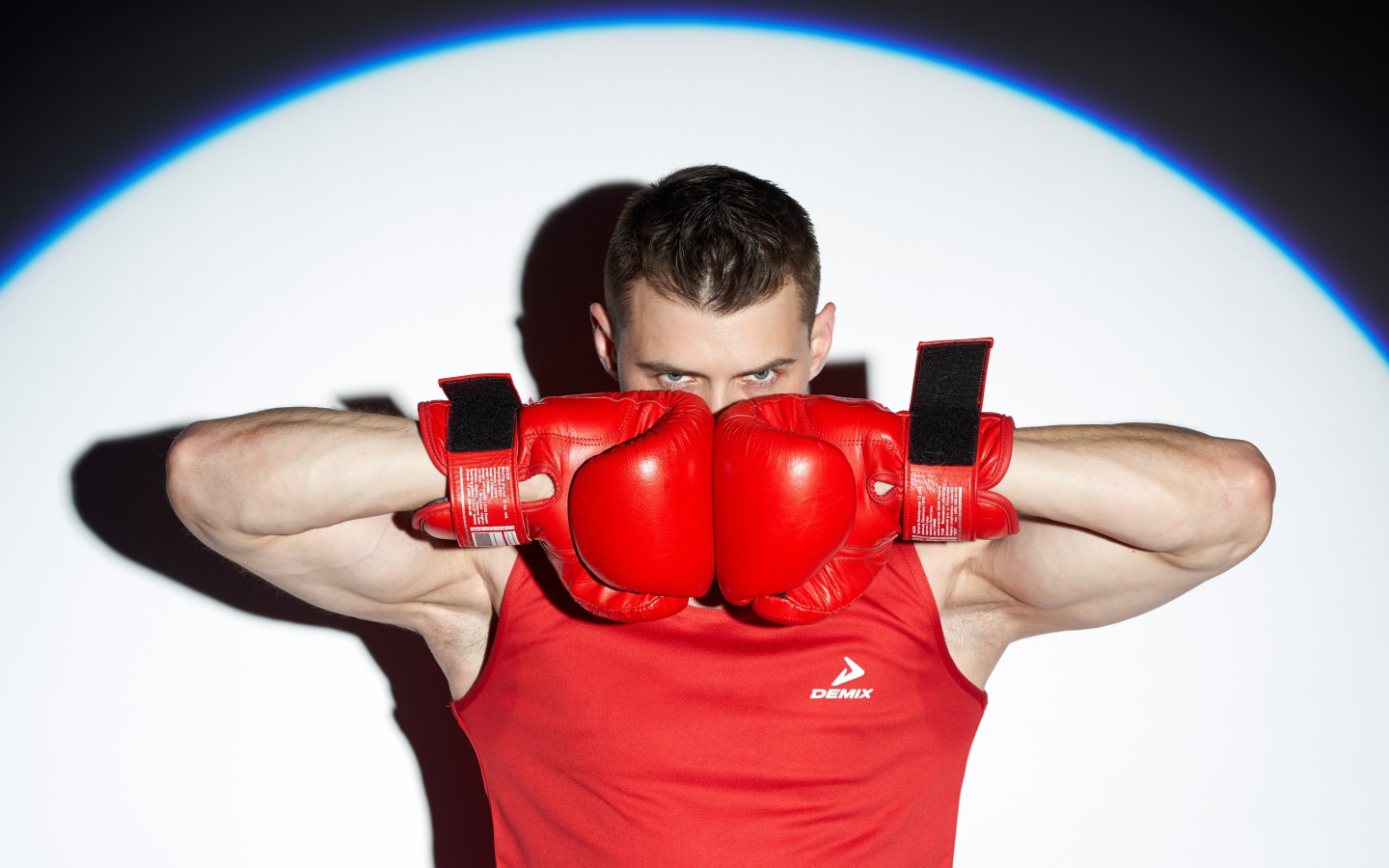 Мужчина боксер с красных перчатках в свете прожектора 