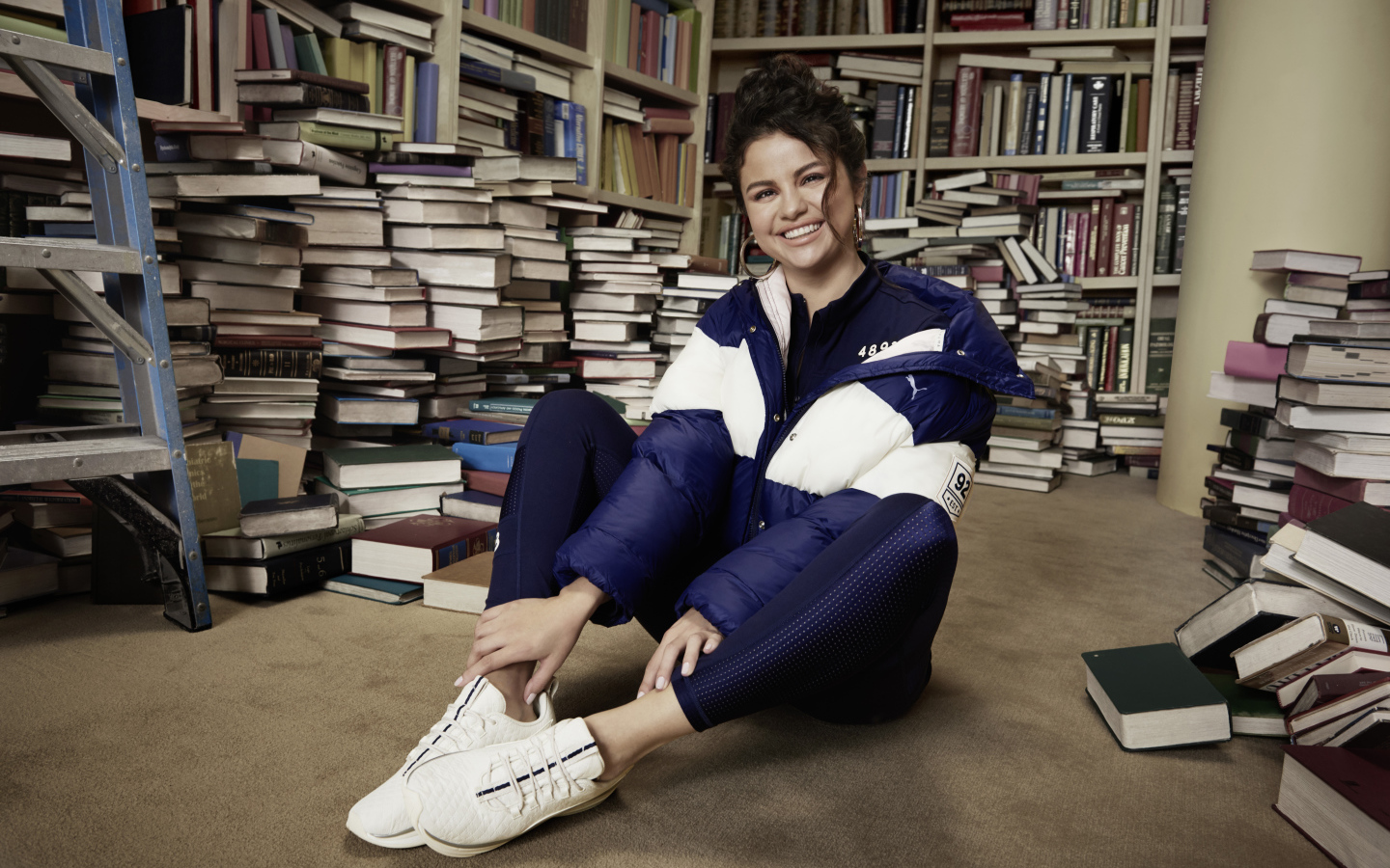 Улыбающаяся певица Селена Гомез в библиотеке 