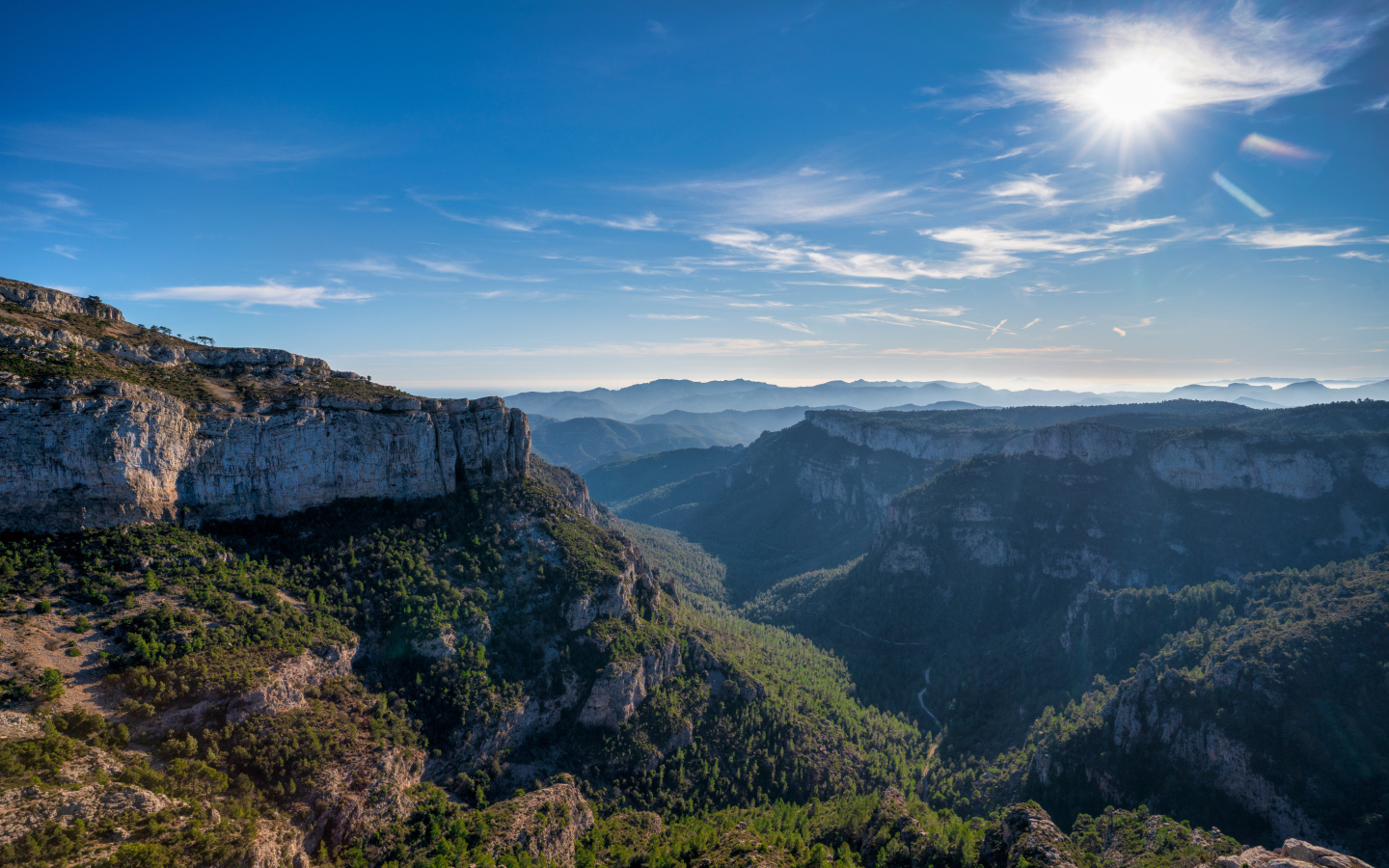 Яркое солнце в голубом небе над высокими горами 
