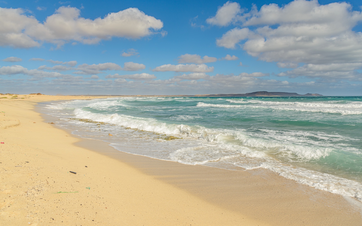 Бушующие морские волны на желтом горячем песке 