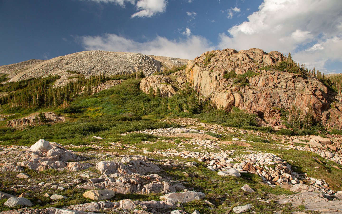 Высокие каменные горы под  голубым небом с белыми облаками
