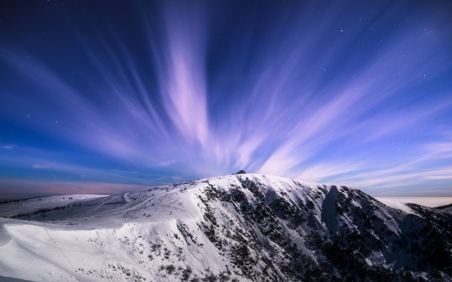 Белые облака в голубом небе над заснеженными горами