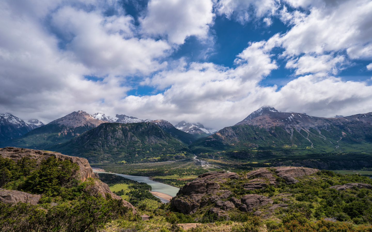 Белые облака в голубом небе над покрытыми зеленью горами