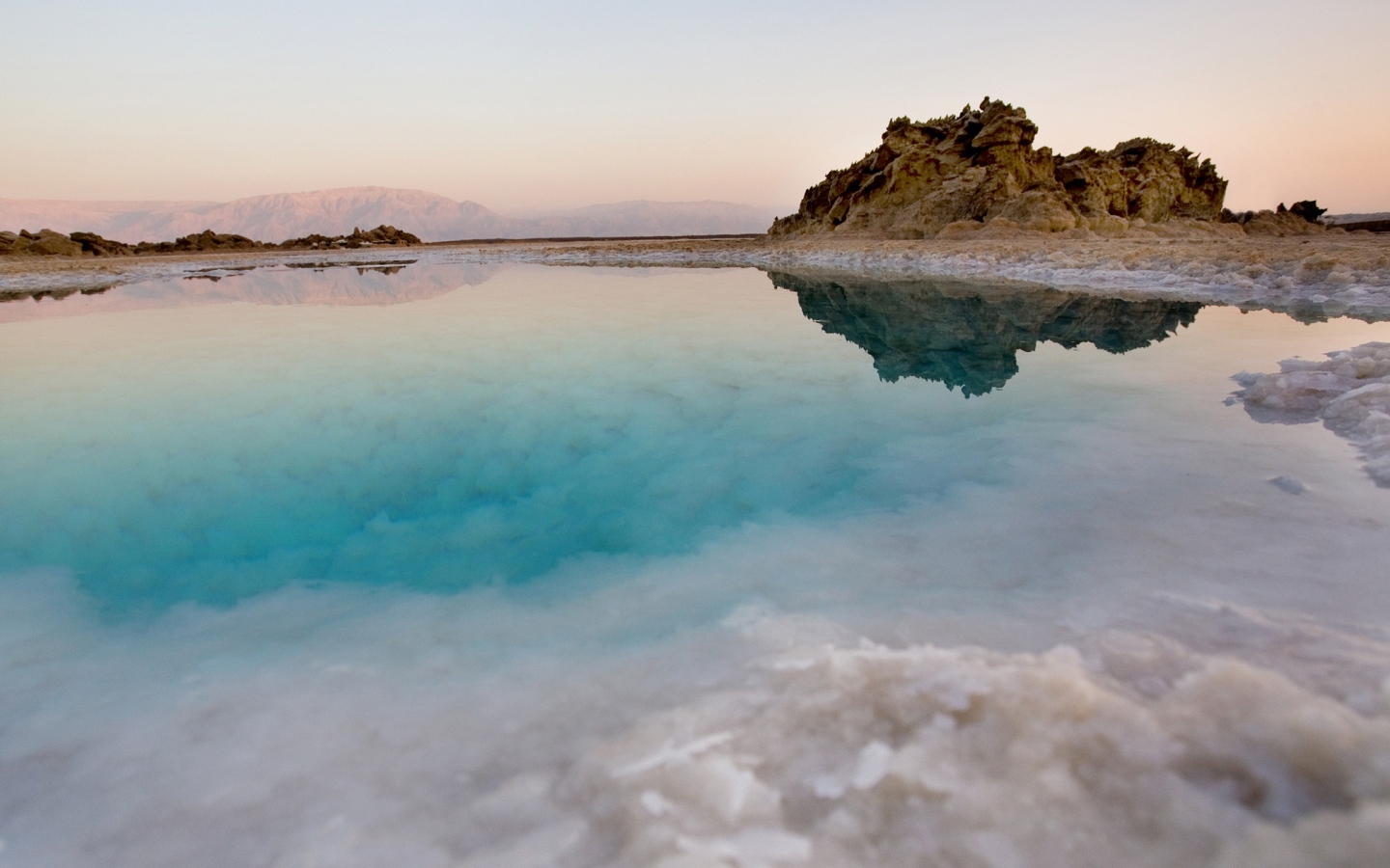 Покрытые льдом берега горного озера с голубой водой