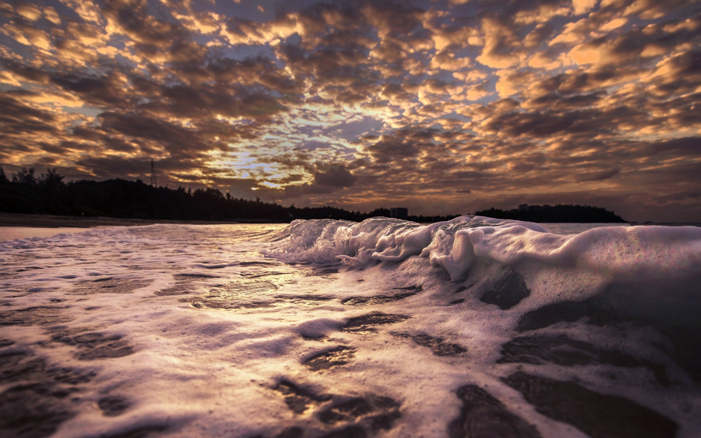 Белые волны на песке на рассвете 