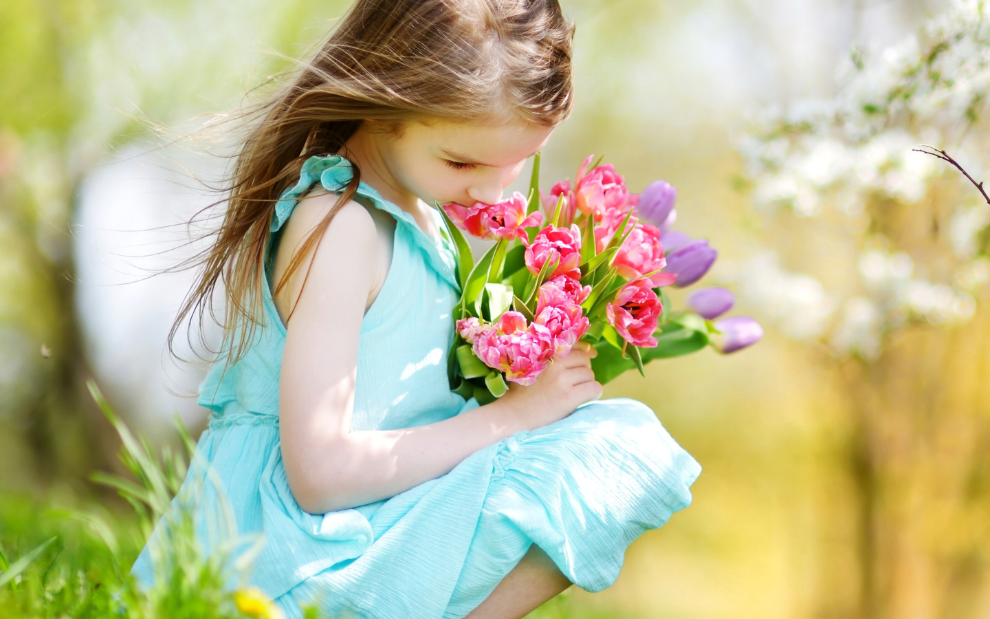 Красивая девочка в голубом платье с букетом тюльпанов