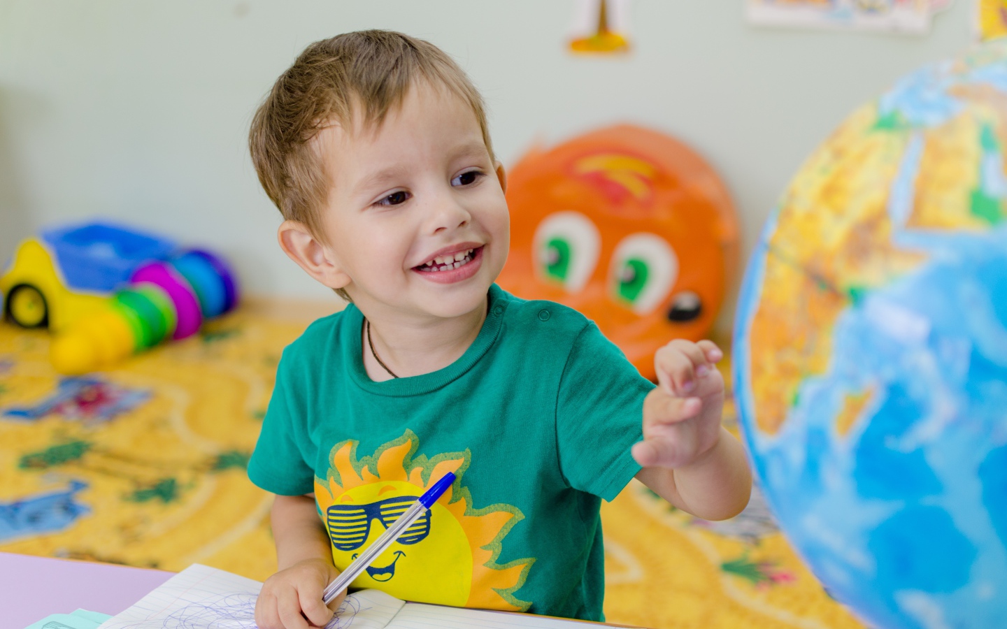 Маленький мальчик изучает глобус 