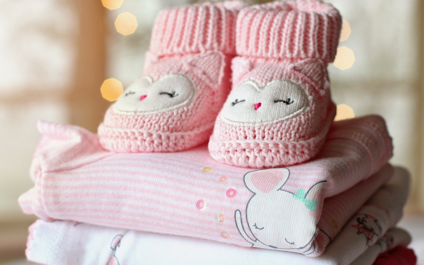 Маленькие розовые пинетки и одежда для малыша 