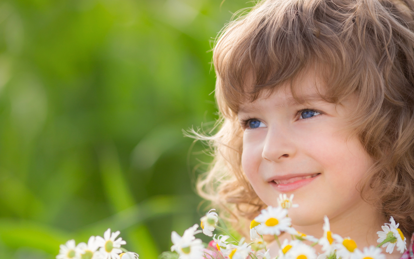 Улыбающаяся девочка с букетом ромашек 