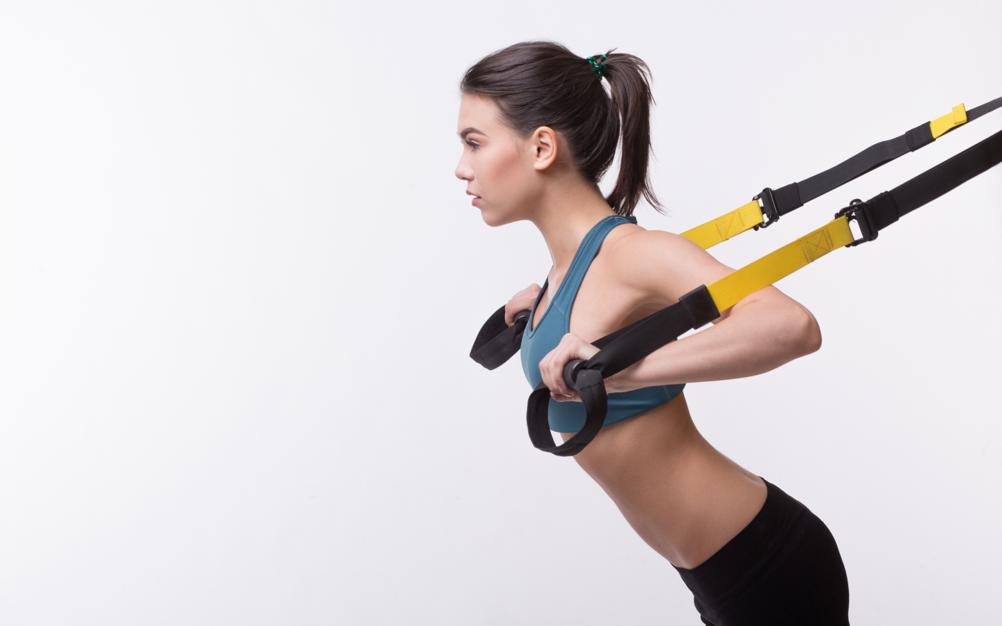 Спортивная девушка занимается в спортзале на белом фоне 