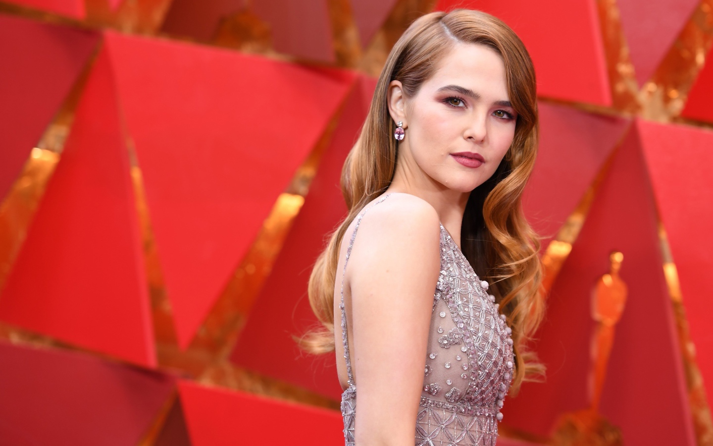 Красивая актриса Зои Дойч в платье на красном фоне