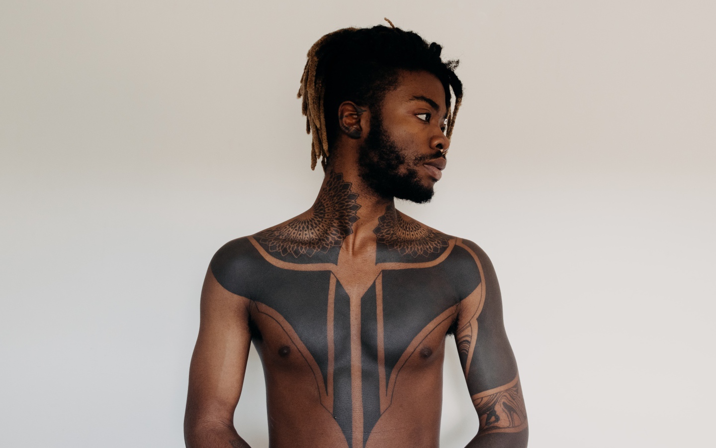 Темнокожий мужчина с татуировками на теле