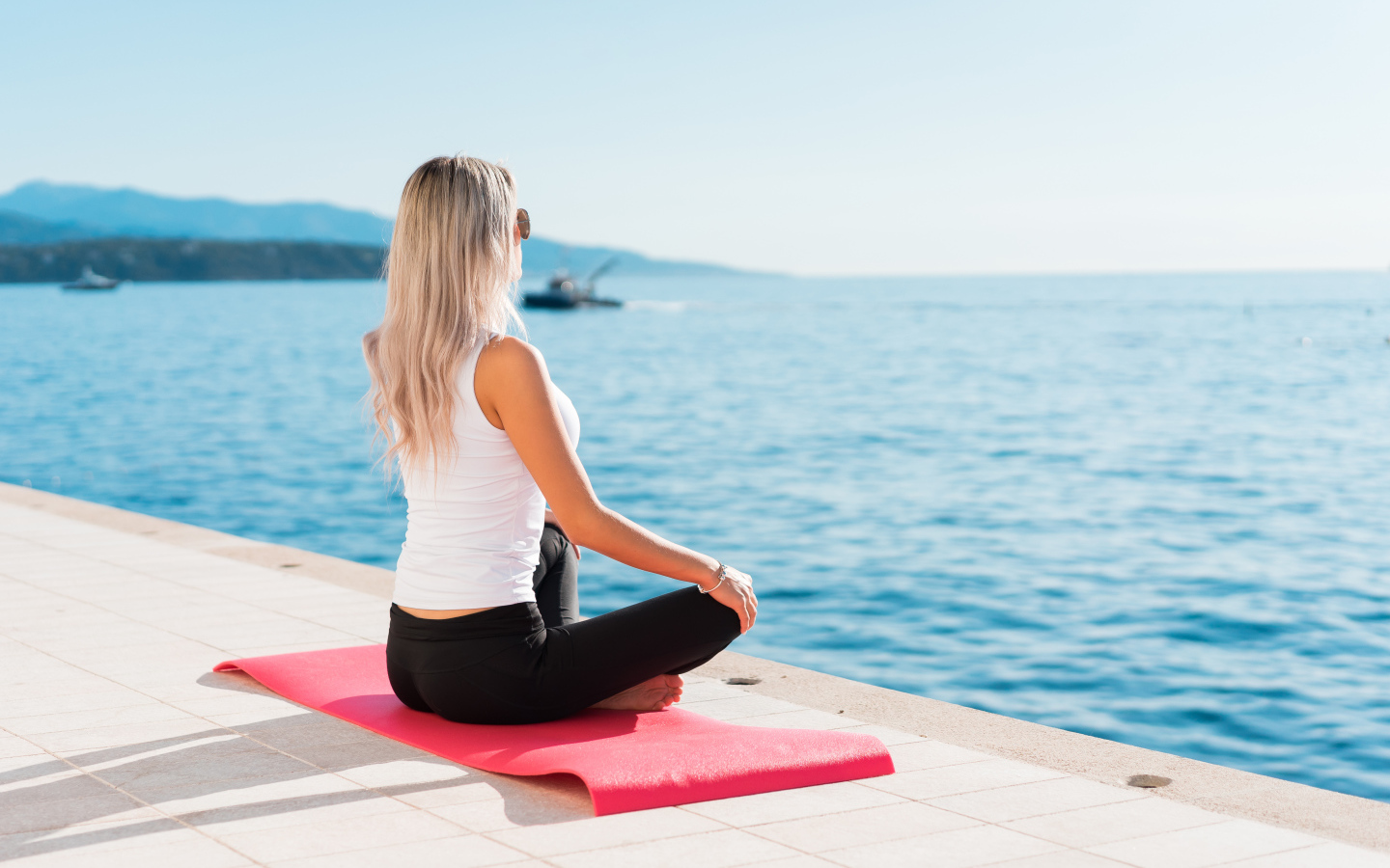 Девушка медитирует на берегу моря 